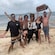 Five Guests and an actor playing Anne Bonny standing on a beach with a treasure chest, sword and goblet